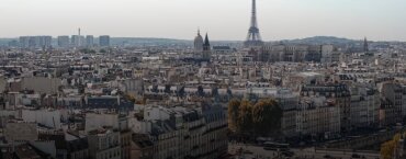 An aerial view of the Paris skyline with the Eiffel Tower in the background.