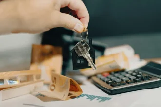 A hand holding house keys with a keychain.